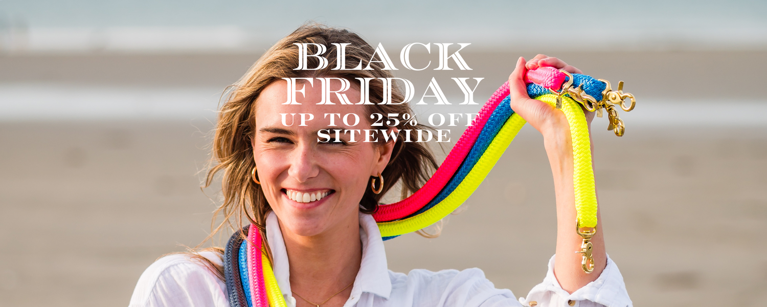 Woman holding colorful bag straps with Black Friday sale text on a blurred beach background
